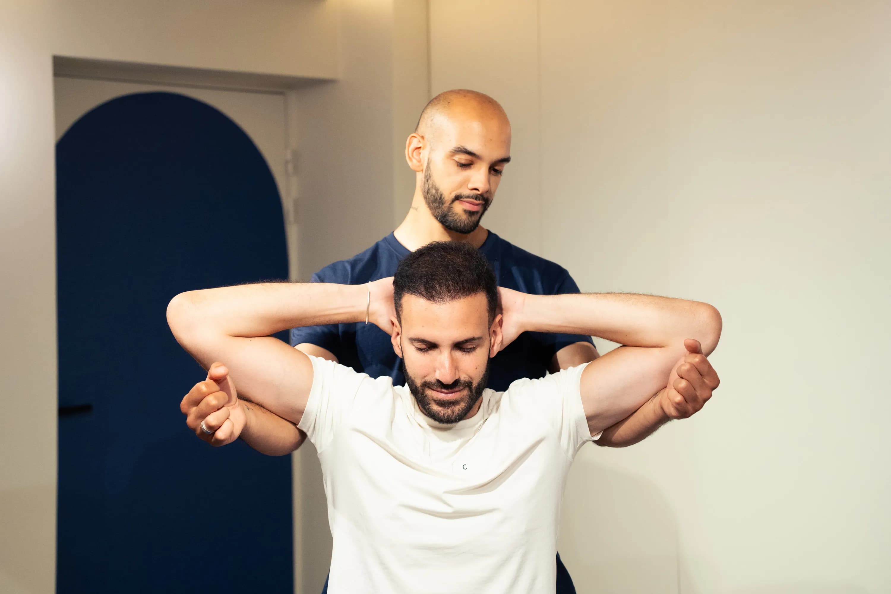 Le flexologue ouvre les épaules, bras croisés derrière la nuque.
